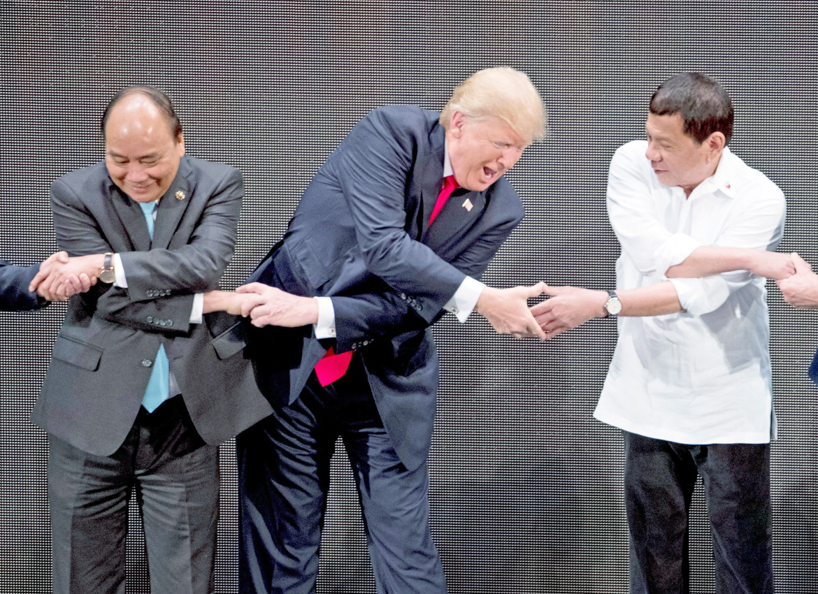 US President Donald Trump, centre does the “ASEAN-Way handshake” with Vietnamese Prime Minister Nguyen Xuan Phuc, left and Philippine President Rodrigo Duterte on stage during the opening ceremony at the ASEAN summit at the Cultural Centre of the Philippines, in Manila Andrew Harnik